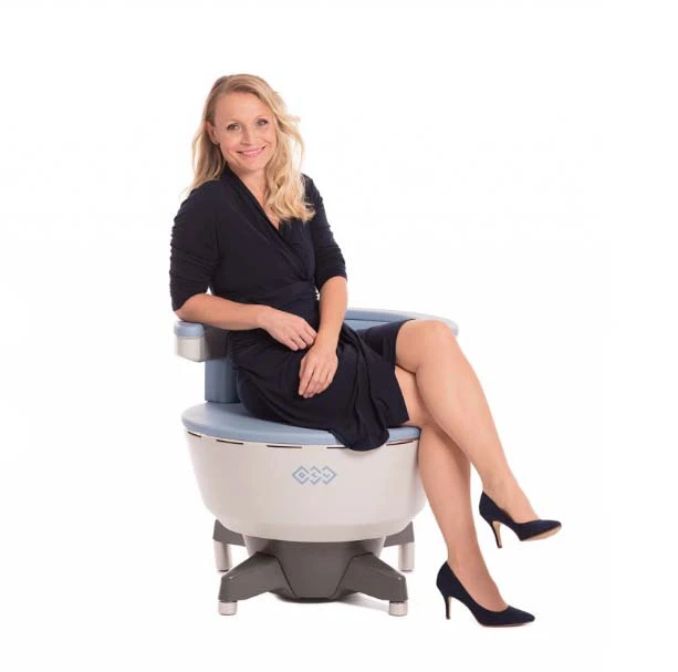 Blonde woman sitting on Emsella chair receiving incontinence treatment.